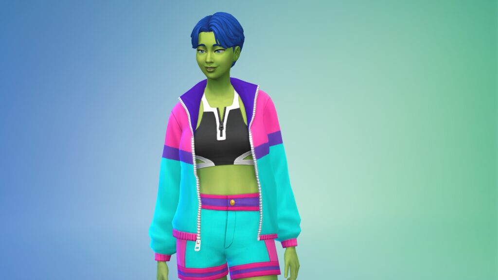 Marietta trägt eine türkis-pinke Jacke mit violetten Akzenten zu einer ebenso gefärbten Jeans und ein schwarz-weißes kurzes Oberteil.