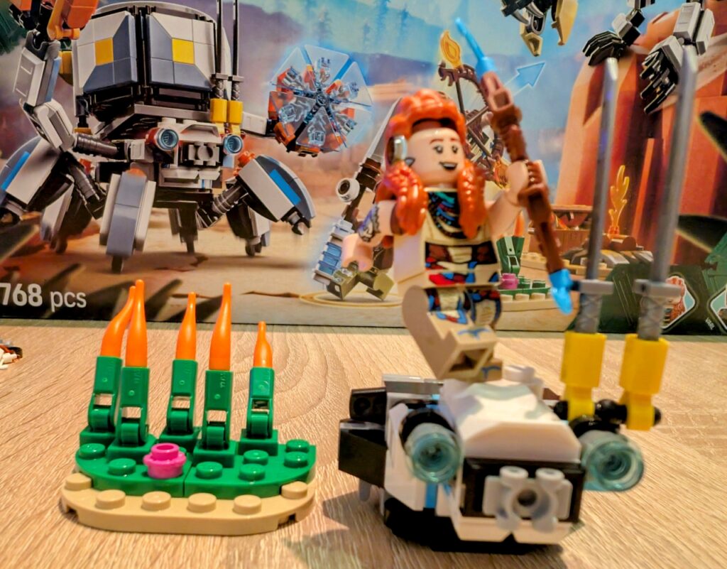 Aloy steht auf dem Kopf des Panzerwanderers, der als einziges bisher aufgebaut ist. Ihre Haare liegen nur noch locker auf, weil sie den Arm weit nach hinten hält.