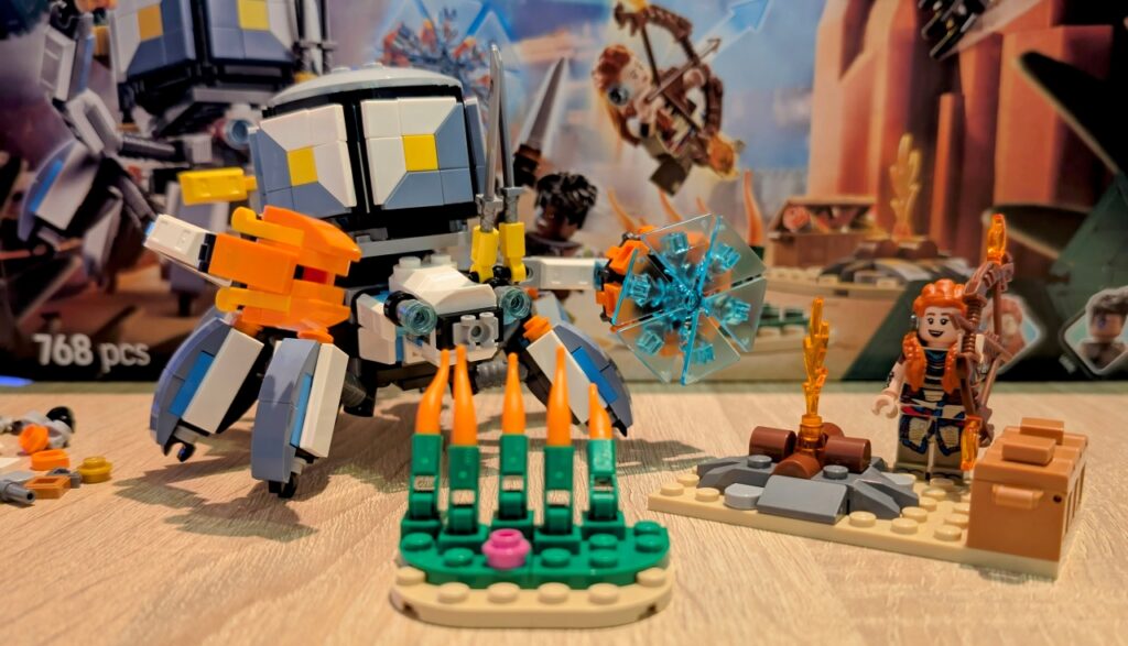 Erste Hälfte aufgebaut: Aloy nebst Lagerfeuer und Truhe, Panzerwanderer hinter dem Gras.