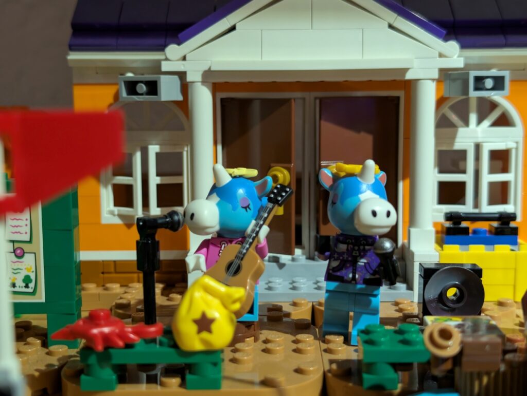Beide Lego-Jimmys vor dem Rathaus, einer sitzend mit Gitarre am Standmikrofon, der andere mit Mikrofon in der Hand daneben.